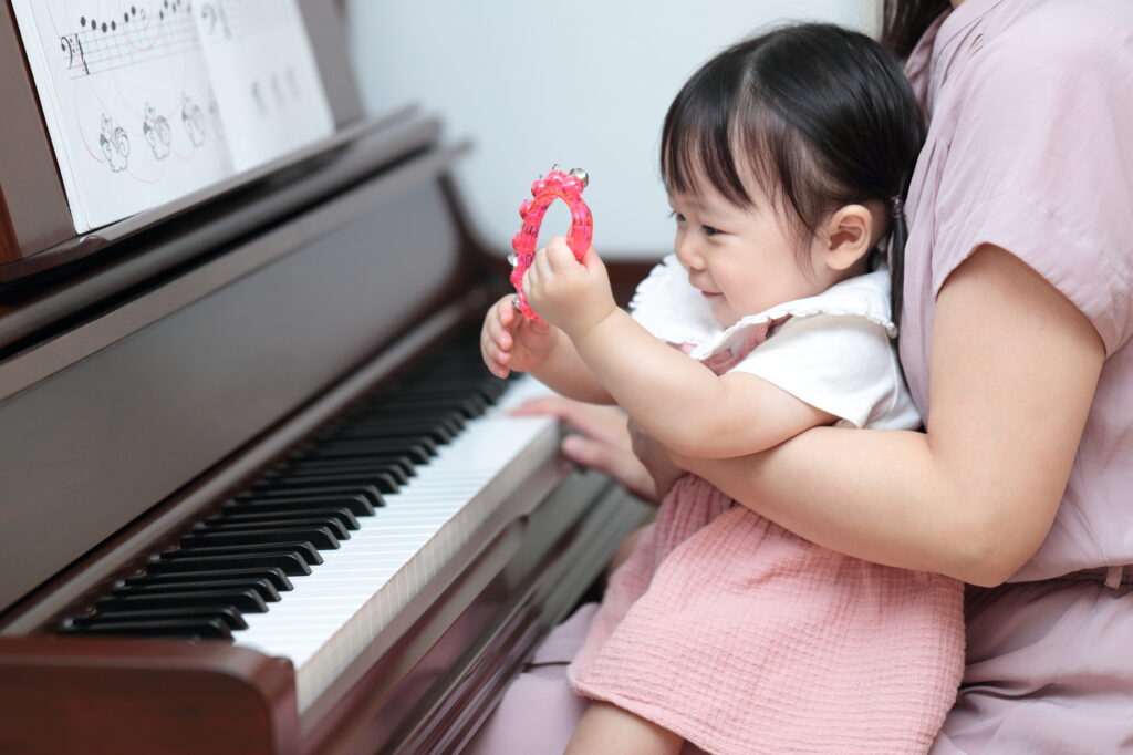 ピアノを弾く1歳の女の子とママ