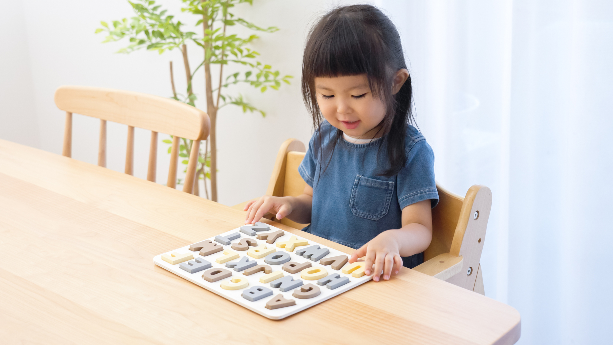 アルファベットパズルで英語の勉強をする子供