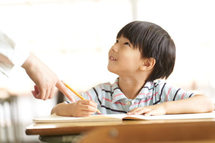 先生の顔を見る幼い男の子